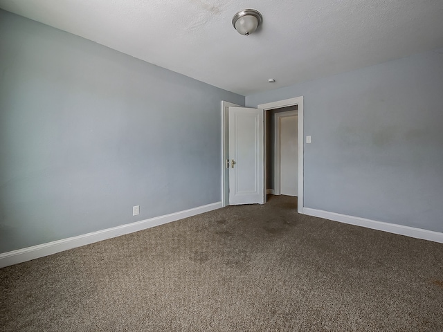 carpeted empty room with a textured ceiling