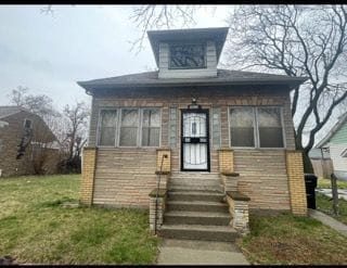 bungalow-style home with a front yard