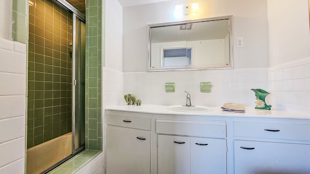 bathroom with decorative backsplash, tile walls, an enclosed shower, and vanity