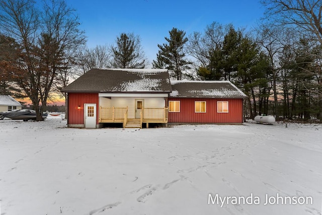 snow covered structure with covered porch