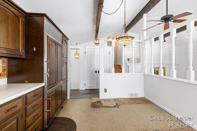 kitchen with visible vents, lofted ceiling with beams, ceiling fan, decorative light fixtures, and light countertops