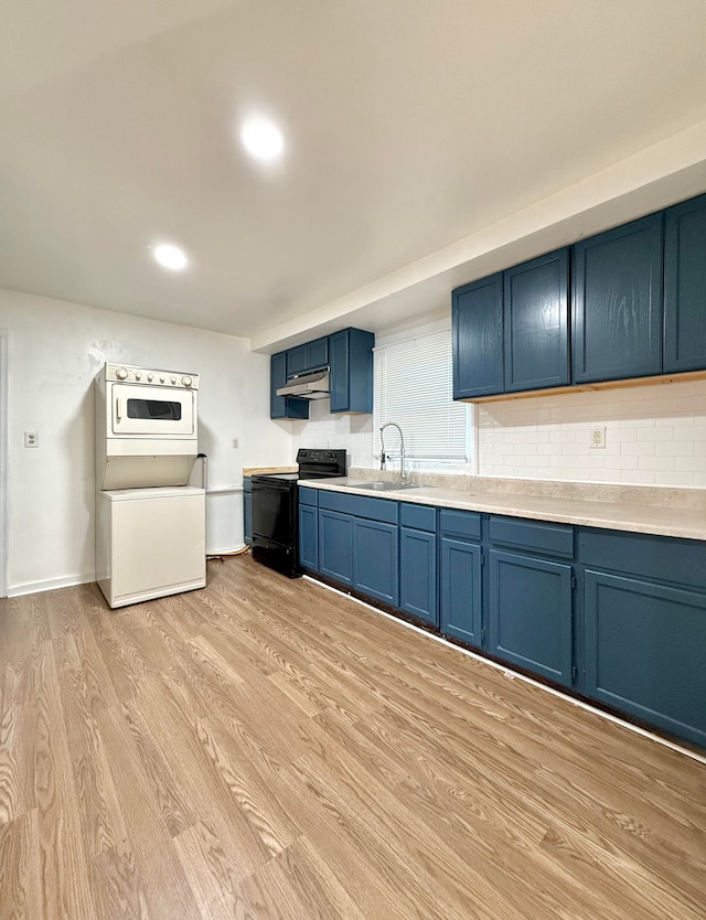 kitchen with stacked washer and clothes dryer, light wood-type flooring, blue cabinets, black / electric stove, and sink