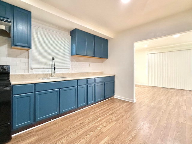 kitchen featuring tasteful backsplash, sink, light wood-type flooring, black / electric stove, and blue cabinets