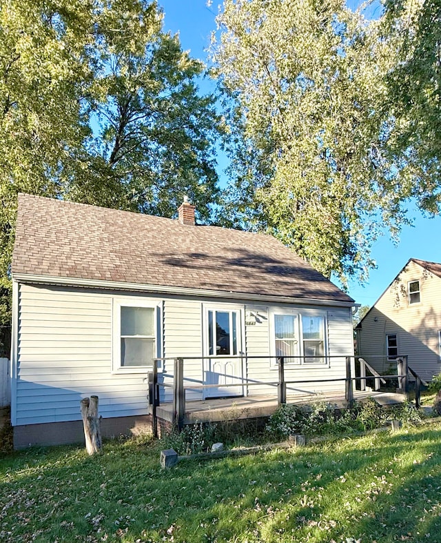 rear view of property with a deck and a yard