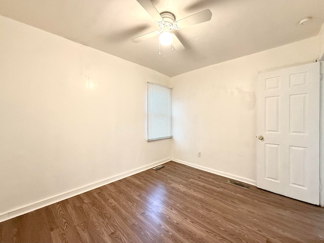 empty room with ceiling fan and dark hardwood / wood-style flooring