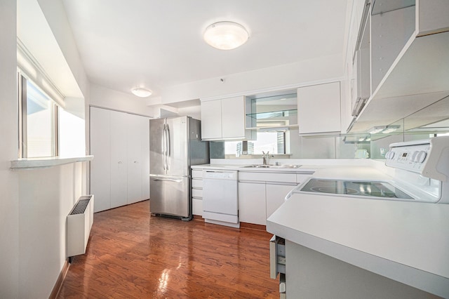 kitchen featuring dishwasher, sink, stainless steel refrigerator, white cabinetry, and radiator heating unit