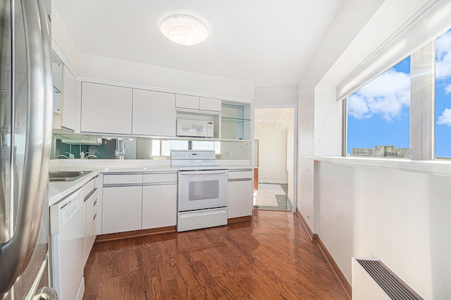 kitchen featuring white cabinetry, white appliances, dark hardwood / wood-style floors, and radiator heating unit