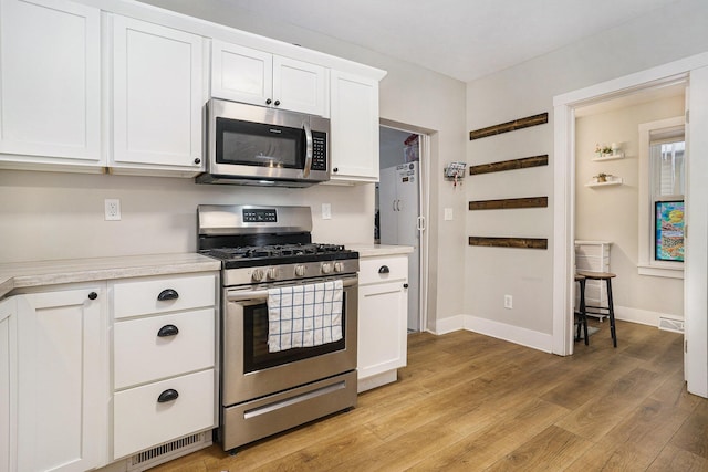 kitchen featuring white cabinetry, light hardwood / wood-style flooring, and stainless steel appliances