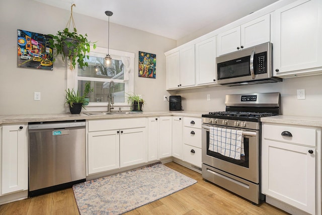 kitchen featuring light hardwood / wood-style floors, sink, white cabinetry, and appliances with stainless steel finishes