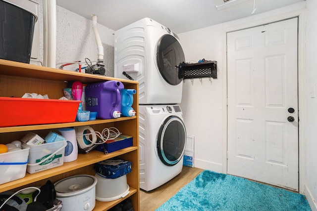 laundry room with stacked washer / dryer and light wood-type flooring