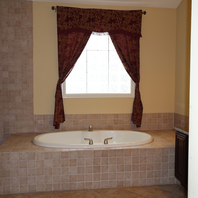 bathroom featuring tiled tub, tile patterned floors, and a wealth of natural light