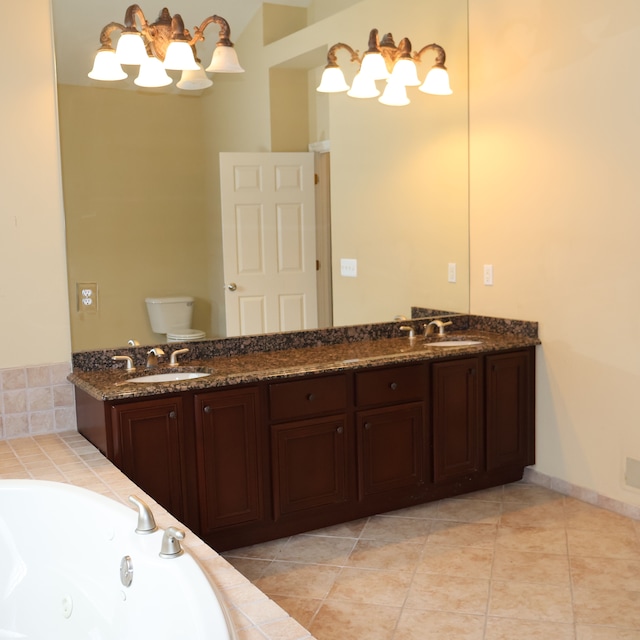 bathroom with toilet, tile patterned flooring, vanity, and a notable chandelier