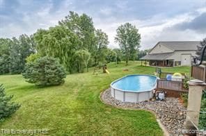 view of pool featuring a deck and a lawn