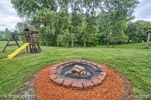 view of yard with an outdoor fire pit and a playground