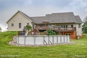 back of property with a yard and a swimming pool side deck