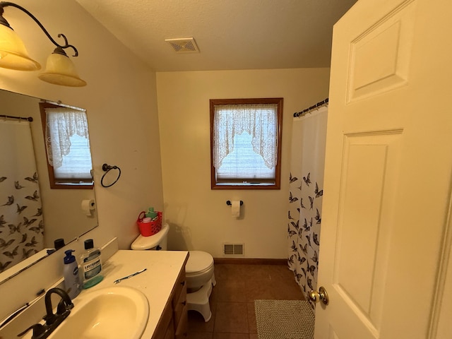 bathroom featuring tile patterned floors, toilet, vanity, and a textured ceiling