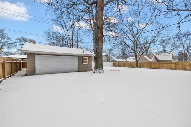 snowy yard with a garage and an outdoor structure