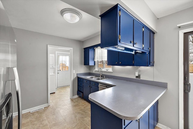 kitchen with kitchen peninsula, dishwasher, sink, and blue cabinetry