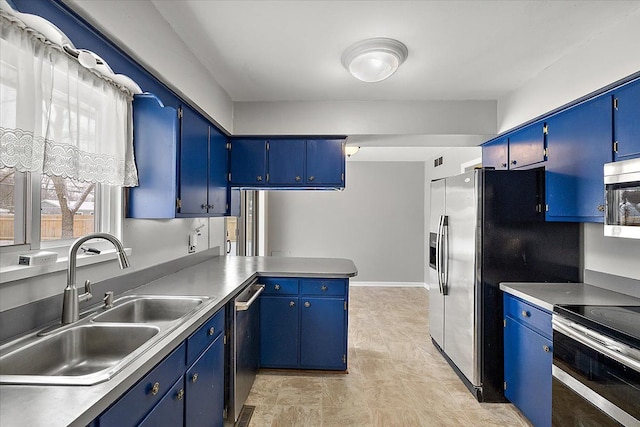 kitchen featuring sink, appliances with stainless steel finishes, kitchen peninsula, and blue cabinets