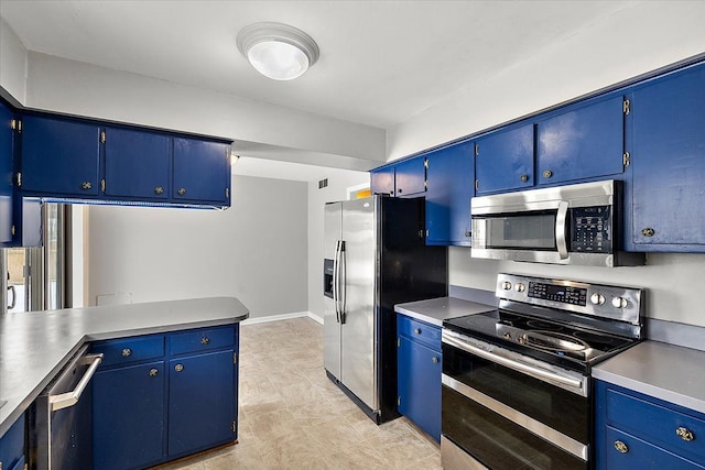 kitchen with blue cabinetry and appliances with stainless steel finishes