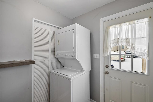 washroom featuring stacked washer and clothes dryer