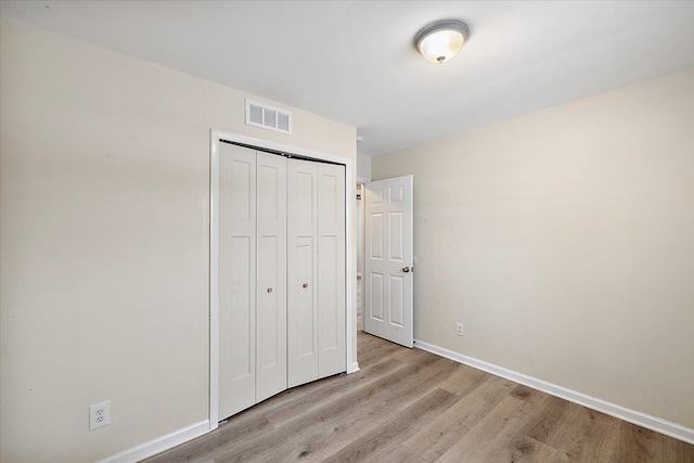 unfurnished bedroom featuring a closet and light wood-type flooring