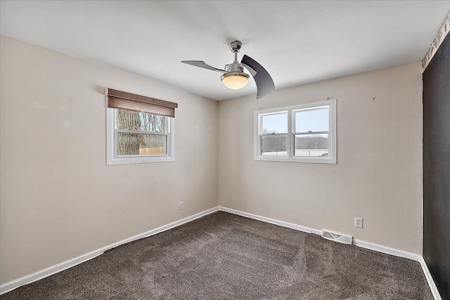 spare room with ceiling fan, a wealth of natural light, and carpet