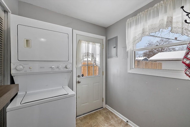 laundry area with electric panel and stacked washer and clothes dryer