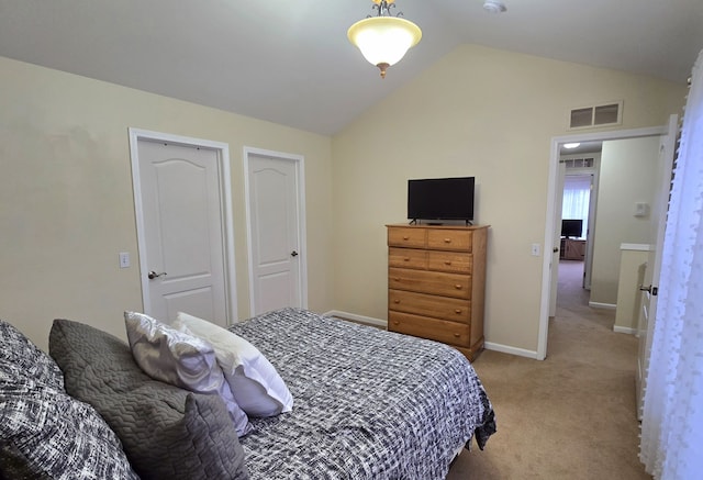 bedroom featuring light colored carpet and vaulted ceiling