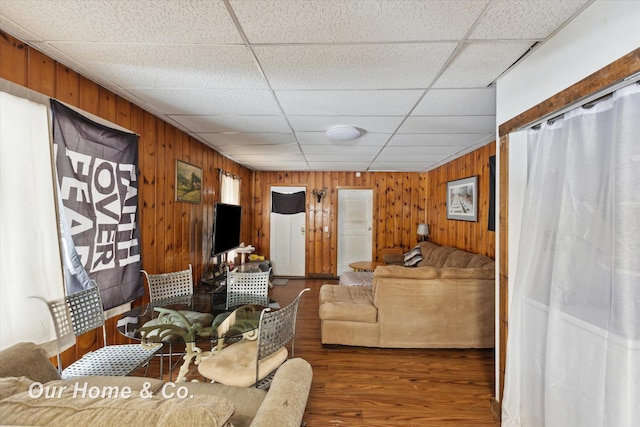 living room with dark wood-type flooring and a paneled ceiling