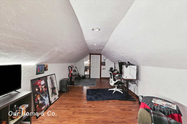 office with a textured ceiling, hardwood / wood-style floors, and vaulted ceiling