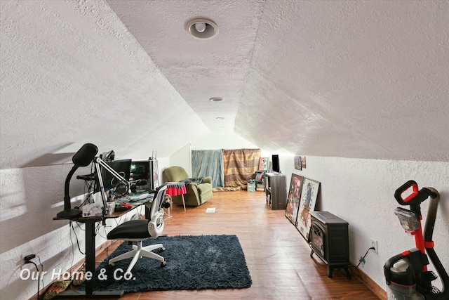 office with a textured ceiling, lofted ceiling, and hardwood / wood-style flooring