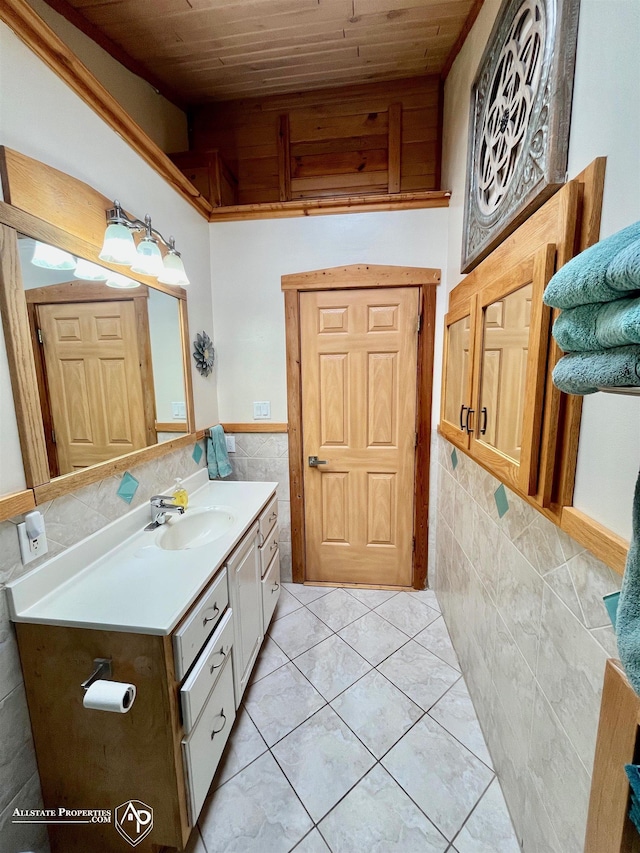 bathroom with vanity, wood ceiling, tile patterned floors, and tile walls