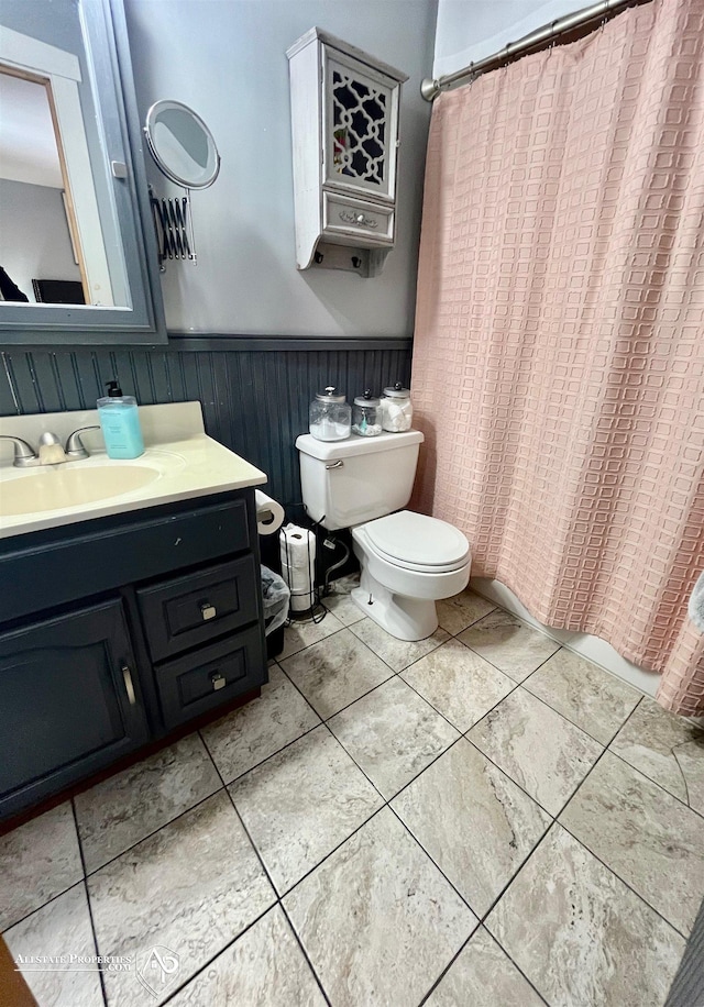 bathroom featuring toilet, a shower with shower curtain, and vanity