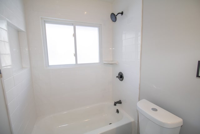 bathroom featuring toilet and tiled shower / bath