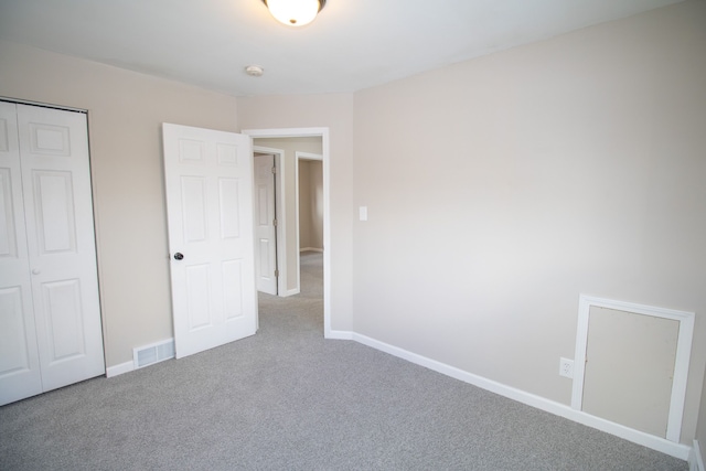 unfurnished bedroom with a closet and carpet flooring