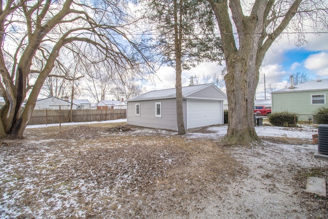 snow covered property featuring an outbuilding and a garage