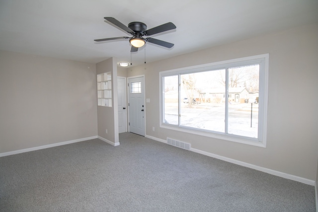 unfurnished room with ceiling fan and carpet flooring