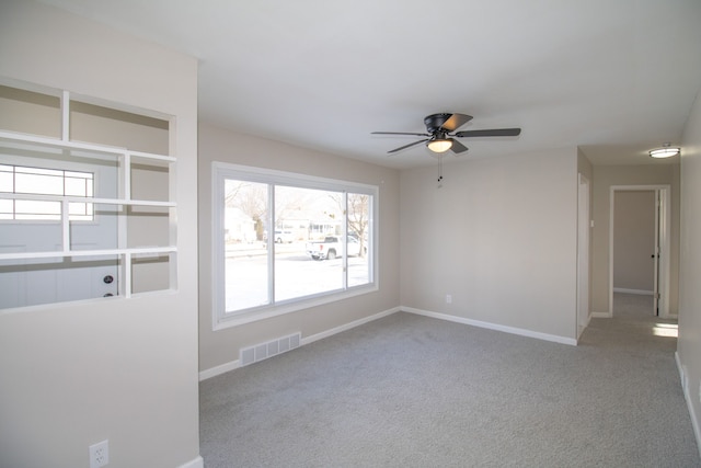 spare room with ceiling fan and light colored carpet