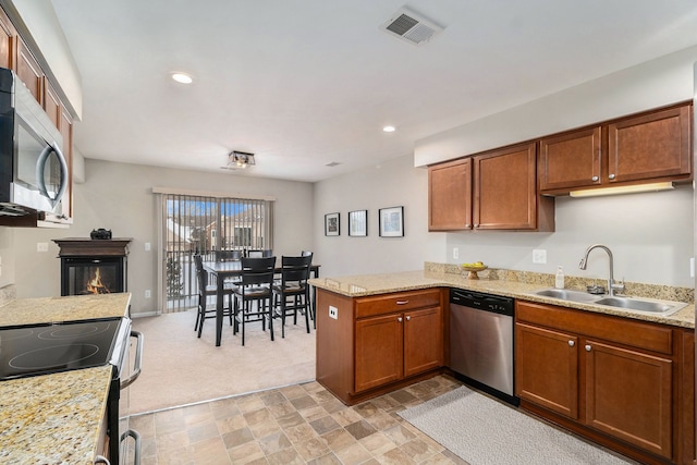 kitchen featuring light colored carpet, kitchen peninsula, sink, and stainless steel appliances