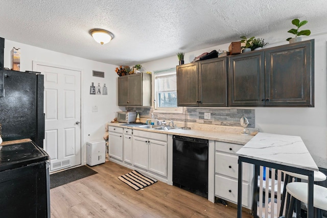 kitchen with backsplash, black appliances, sink, light hardwood / wood-style flooring, and white cabinets