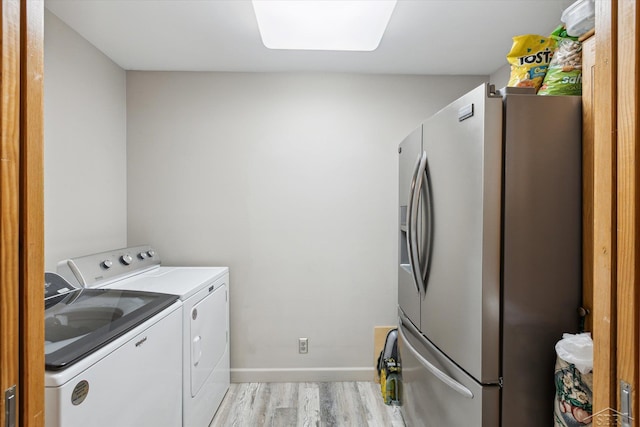 clothes washing area featuring light wood-type flooring and washer and dryer