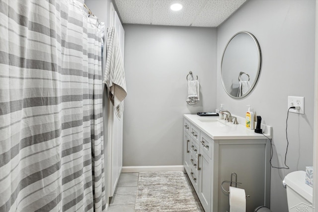 bathroom featuring toilet, tile patterned floors, a drop ceiling, and vanity