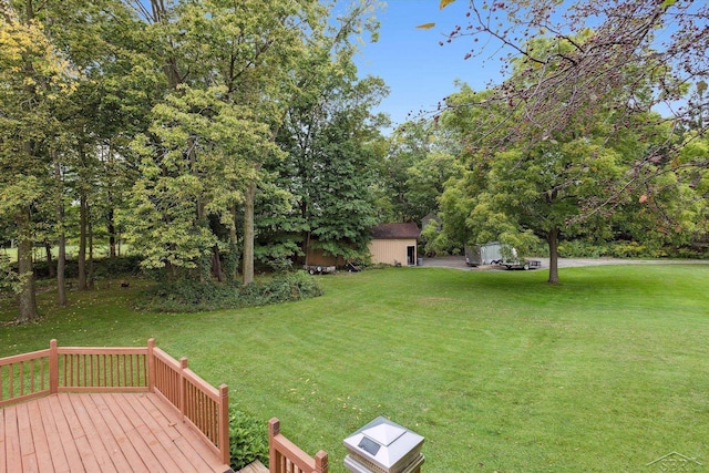 view of yard with a wooden deck and a storage unit