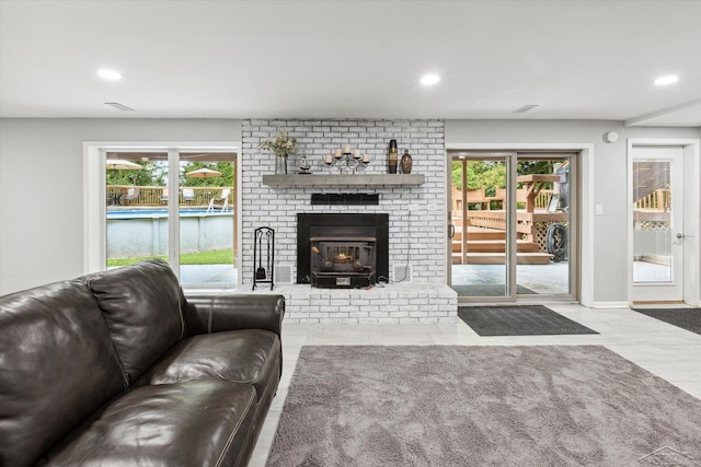 living room with a brick fireplace and a wealth of natural light