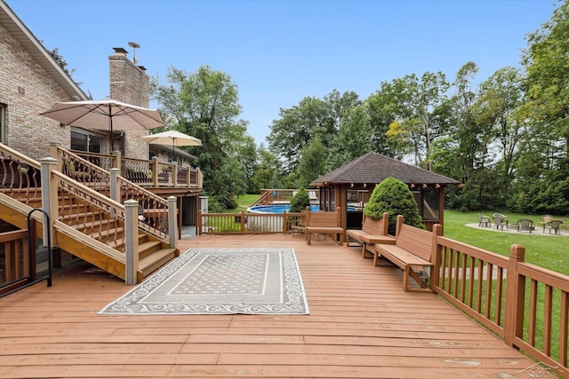 wooden terrace featuring a gazebo and a fire pit