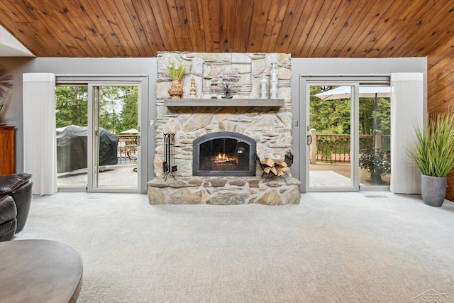 carpeted living room featuring wooden ceiling and a fireplace