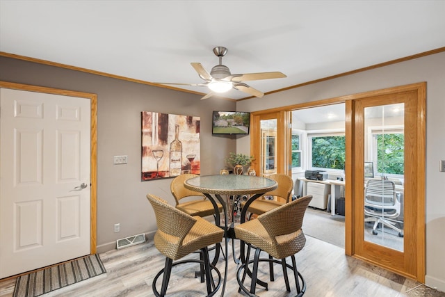 dining room featuring ceiling fan, light wood-type flooring, and ornamental molding