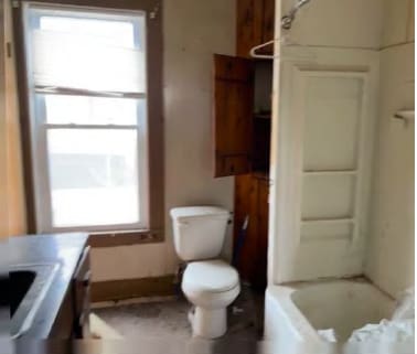 full bathroom featuring toilet, a wealth of natural light, shower / washtub combination, and vanity