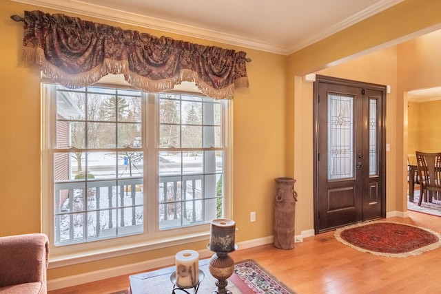 foyer featuring light wood-type flooring and ornamental molding